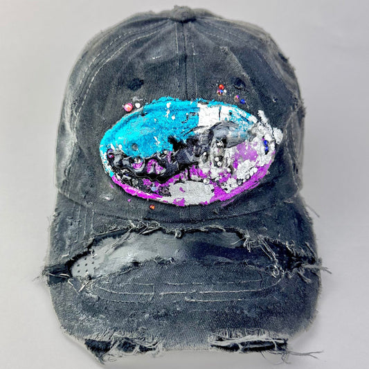 Cover image of ASTROBOI* Technicolor black distressed hat with multicolor metallic New Orleans logo, rhinestones sealed in resin and ripped visor detail.