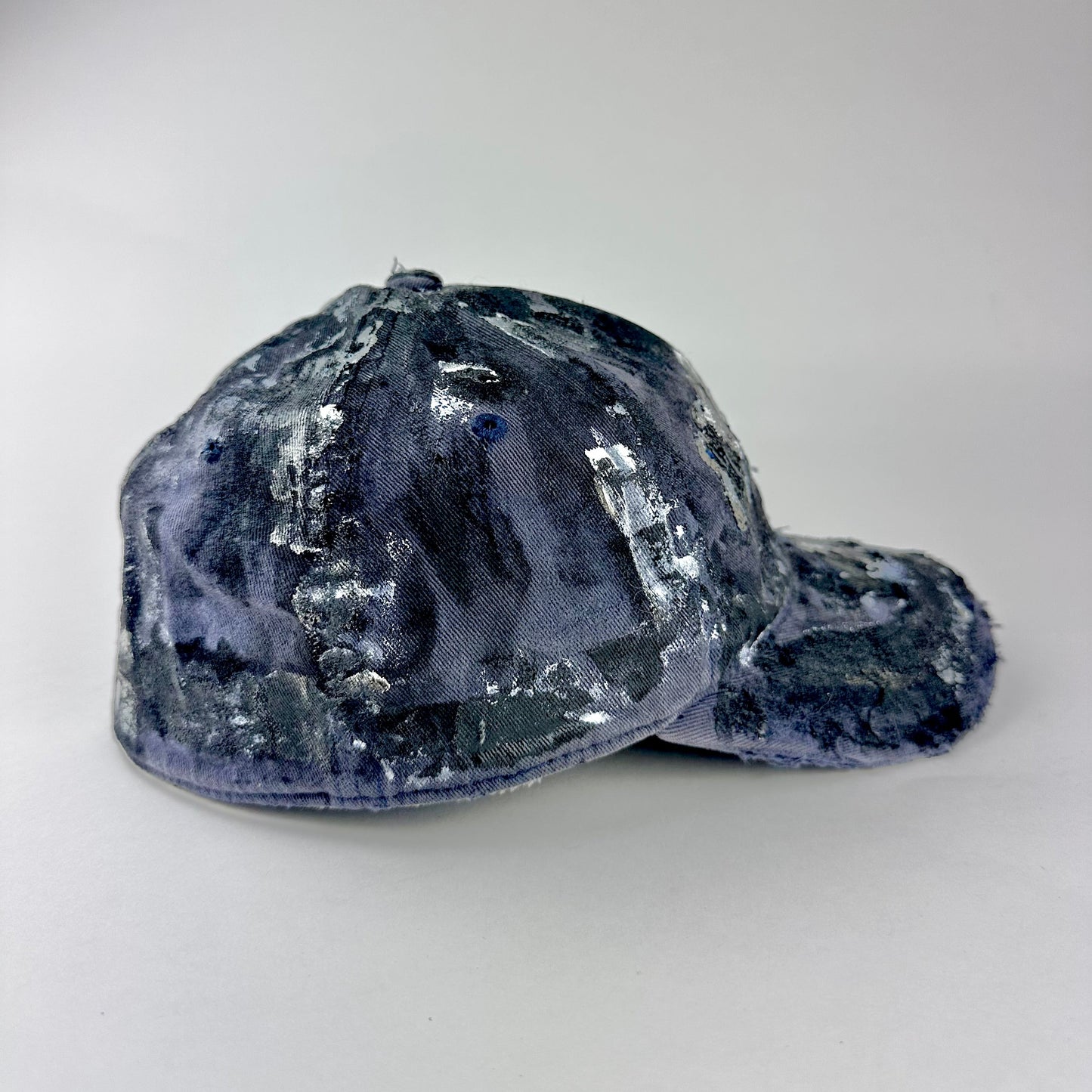 Right side of ASTROBOI* navy fitted cap with custom black, white, and silver paint and distressed vintage finish.