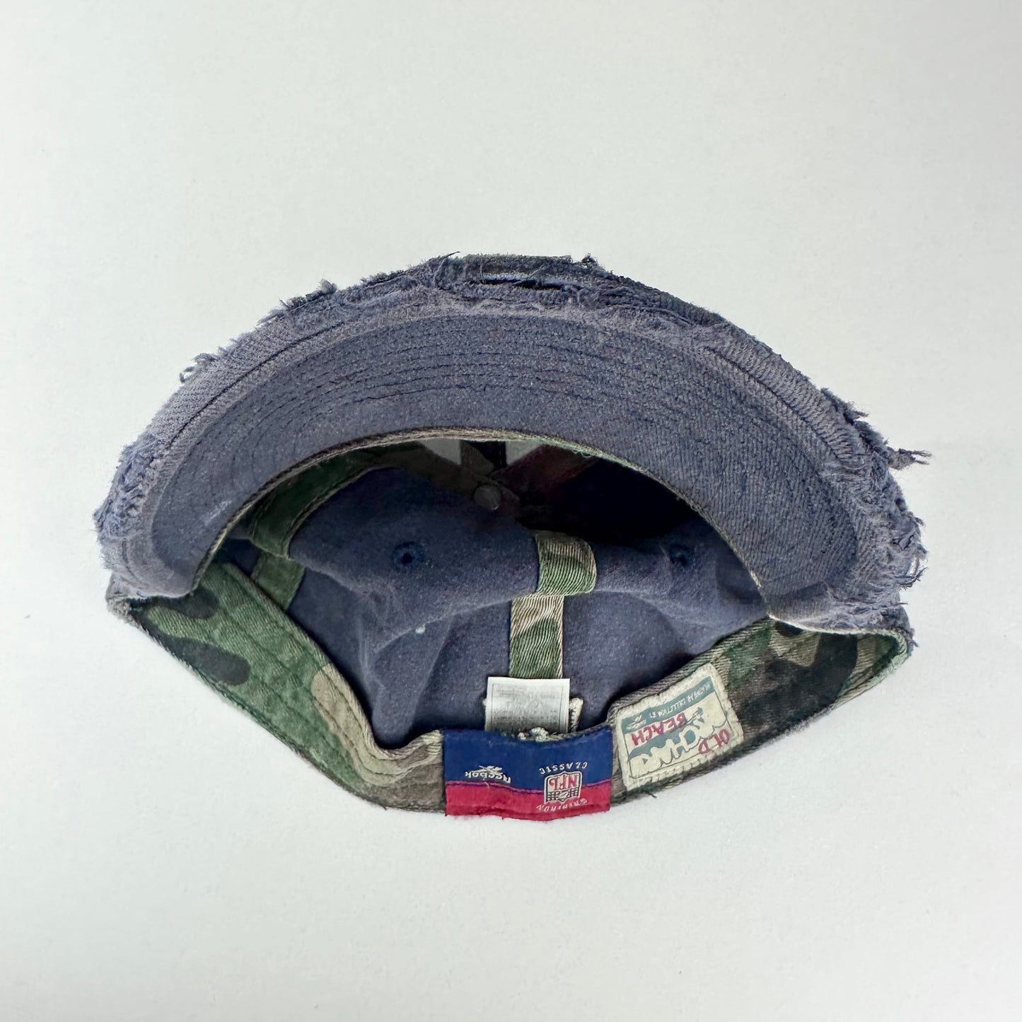 Back of ASTROBOI* navy fitted cap with custom black, white, and silver paint and distressed vintage finish.