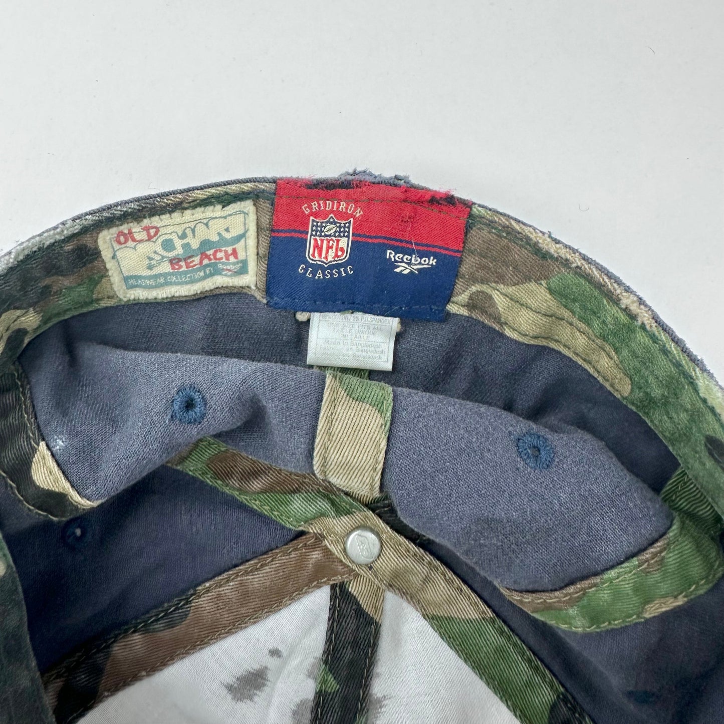 Tag detail on of ASTROBOI* navy fitted cap with custom black, white, and silver paint and distressed vintage finish.