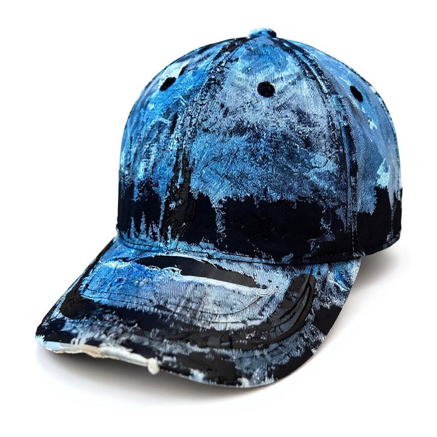 3d image of ASTROBOI* white trompe l’oeil denim print hat with blue and black paint, resin accents, and distressed detailing.
