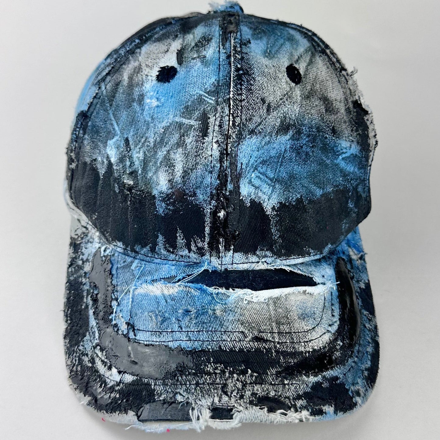 Cover image of ASTROBOI* white trompe l’oeil denim print hat with blue and black paint, resin accents, and distressed detailing.