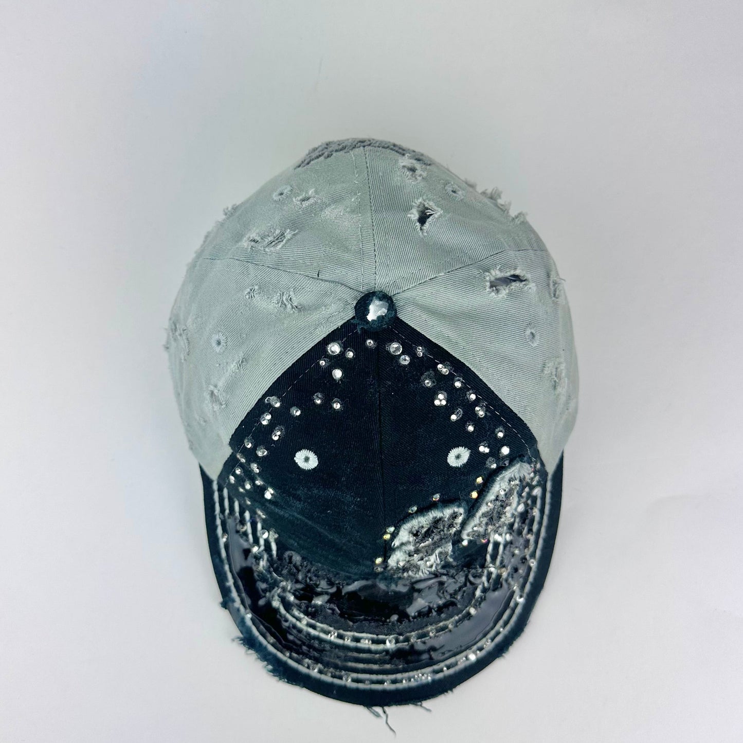 Top of ASTROBOI* “24” black racing cap with silver rhinestones, white stitching, glossy black resin details, and adjustable Velcro back closure.