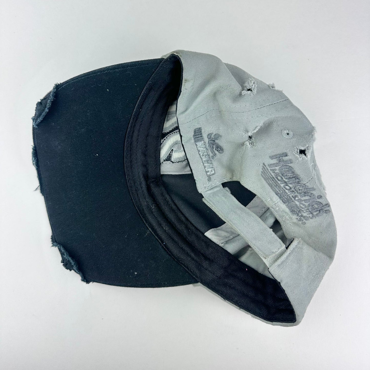 Back of ASTROBOI* “24” black racing cap with silver rhinestones, white stitching, glossy black resin details, and adjustable Velcro back closure.