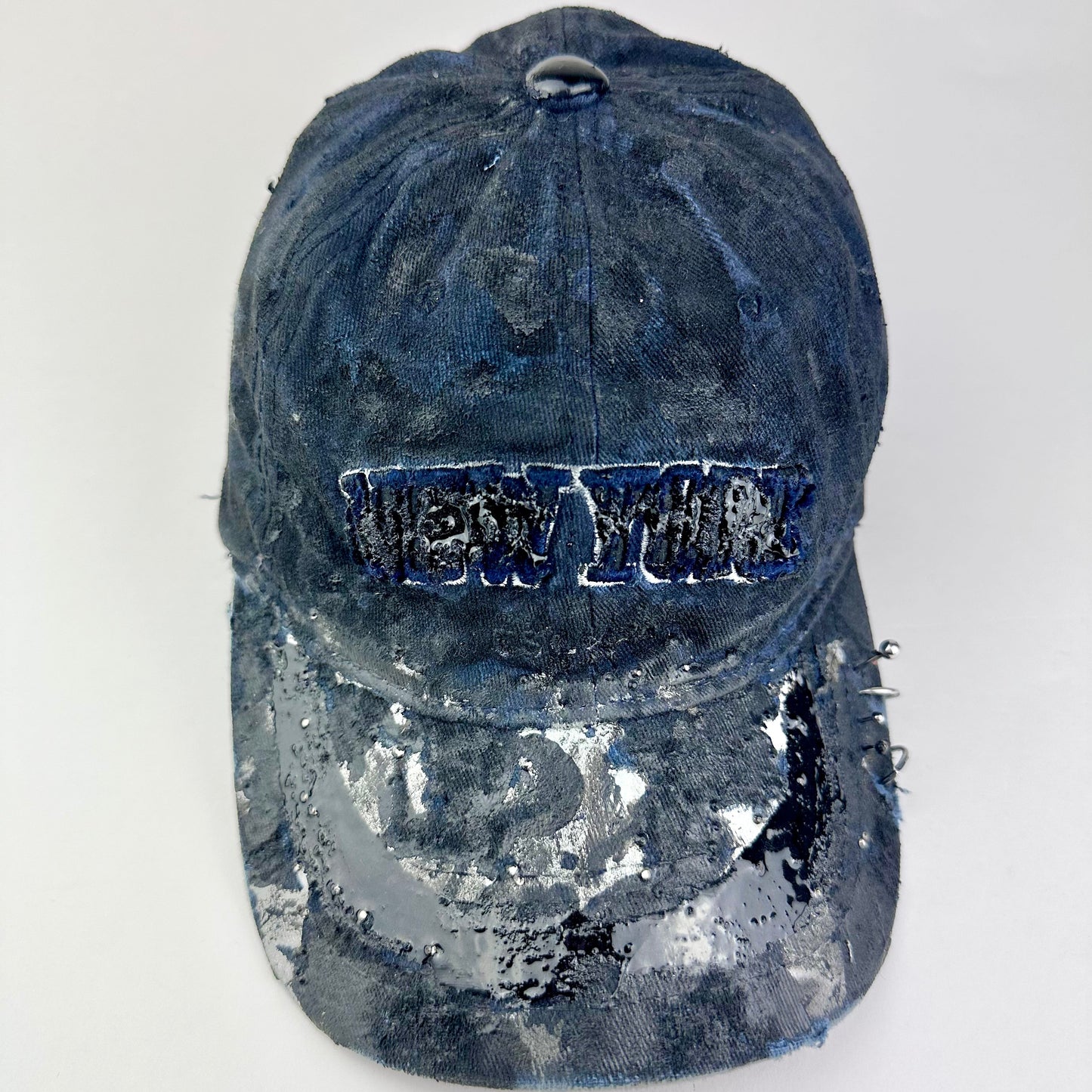 Front of ASTROBOI* Zypher NYC navy distressed hat with metallic silver paint, black resin logo and brim, adjustable back streetwear cap.