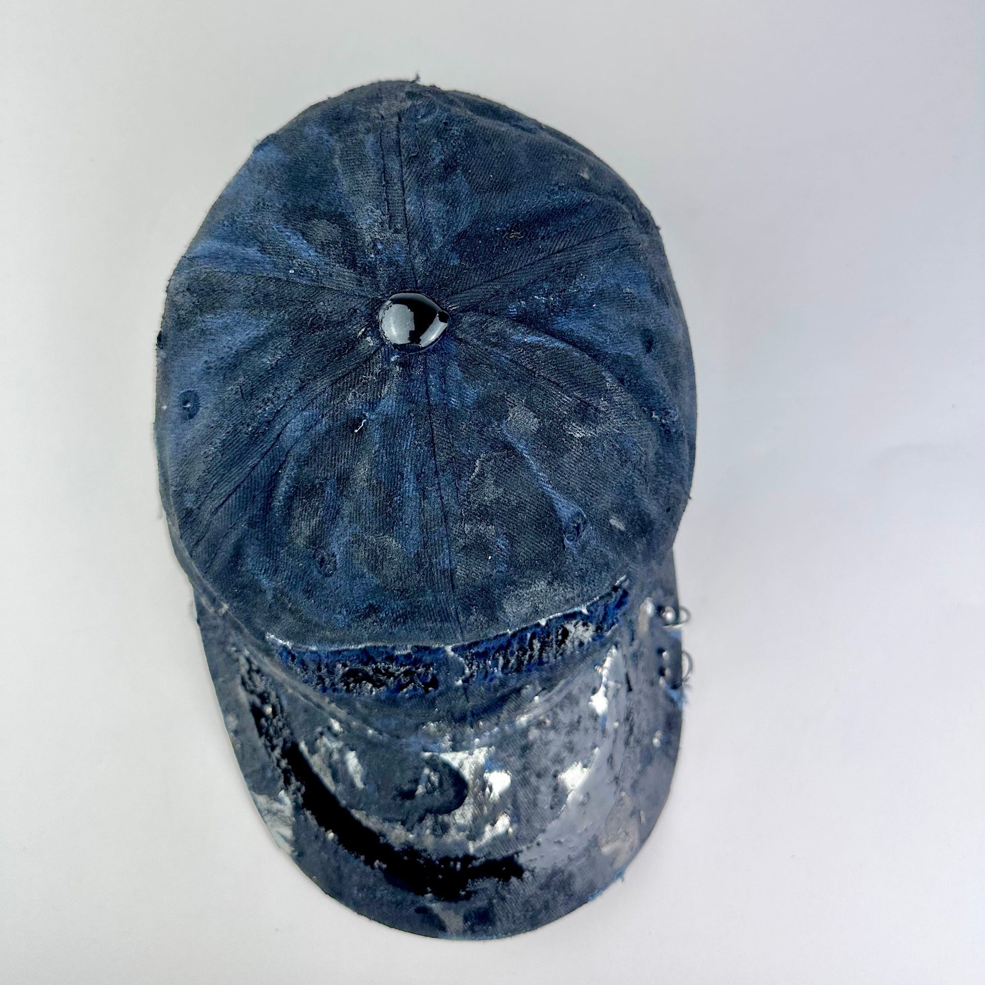 Top of ASTROBOI* Zypher NYC navy distressed hat with metallic silver paint, black resin logo and brim, adjustable back streetwear cap.