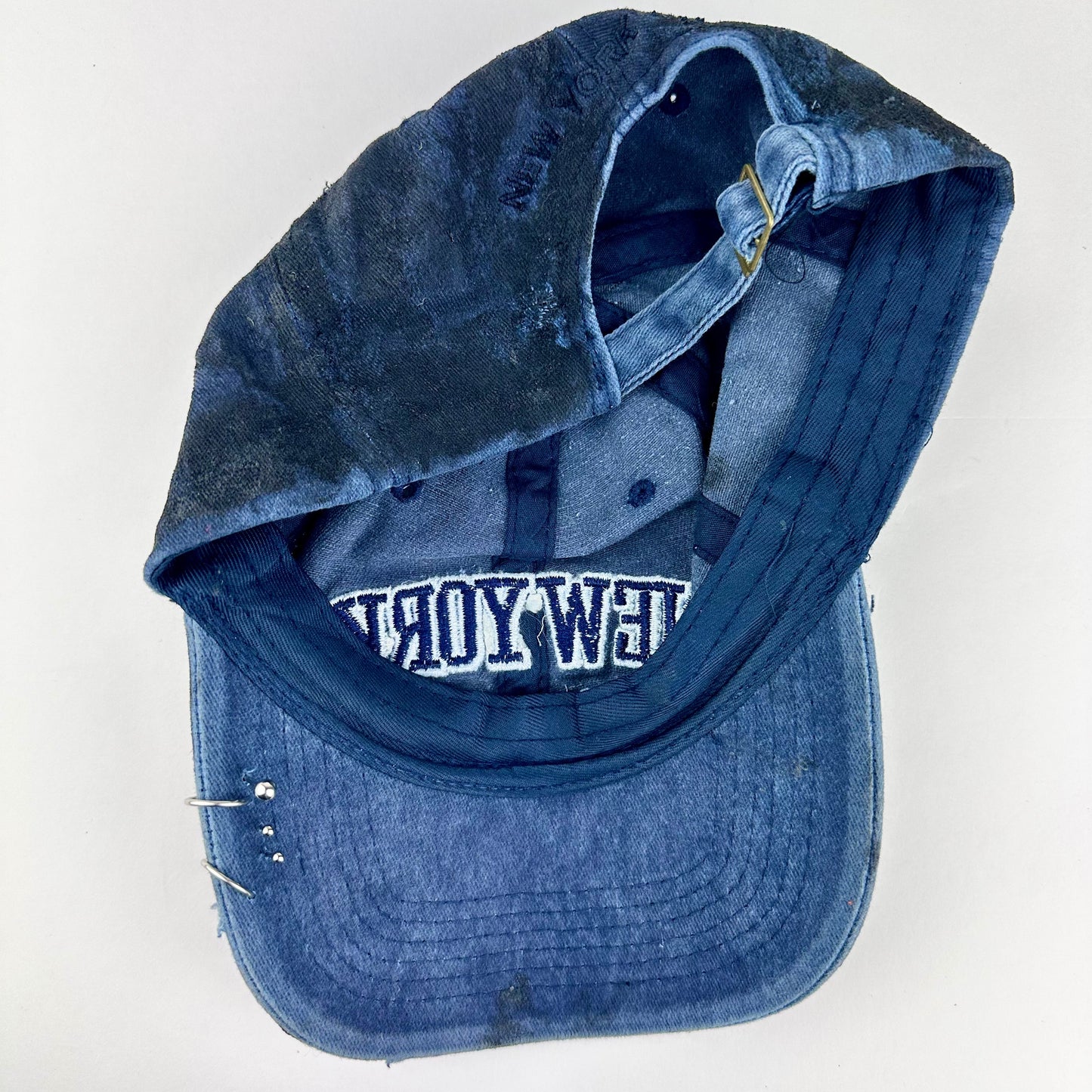 Back of ASTROBOI* Zypher NYC navy distressed hat with metallic silver paint, black resin logo and brim, adjustable back streetwear cap.