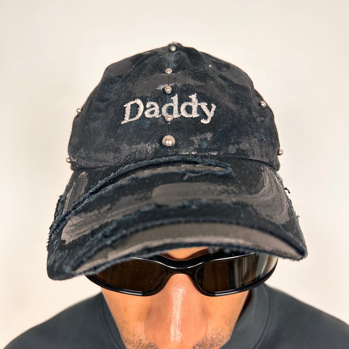 Front of Black distressed ASTROBOI* ‘Daddy’ hat with custom paint detailing and stainless steel piercings, handcrafted in NYC.