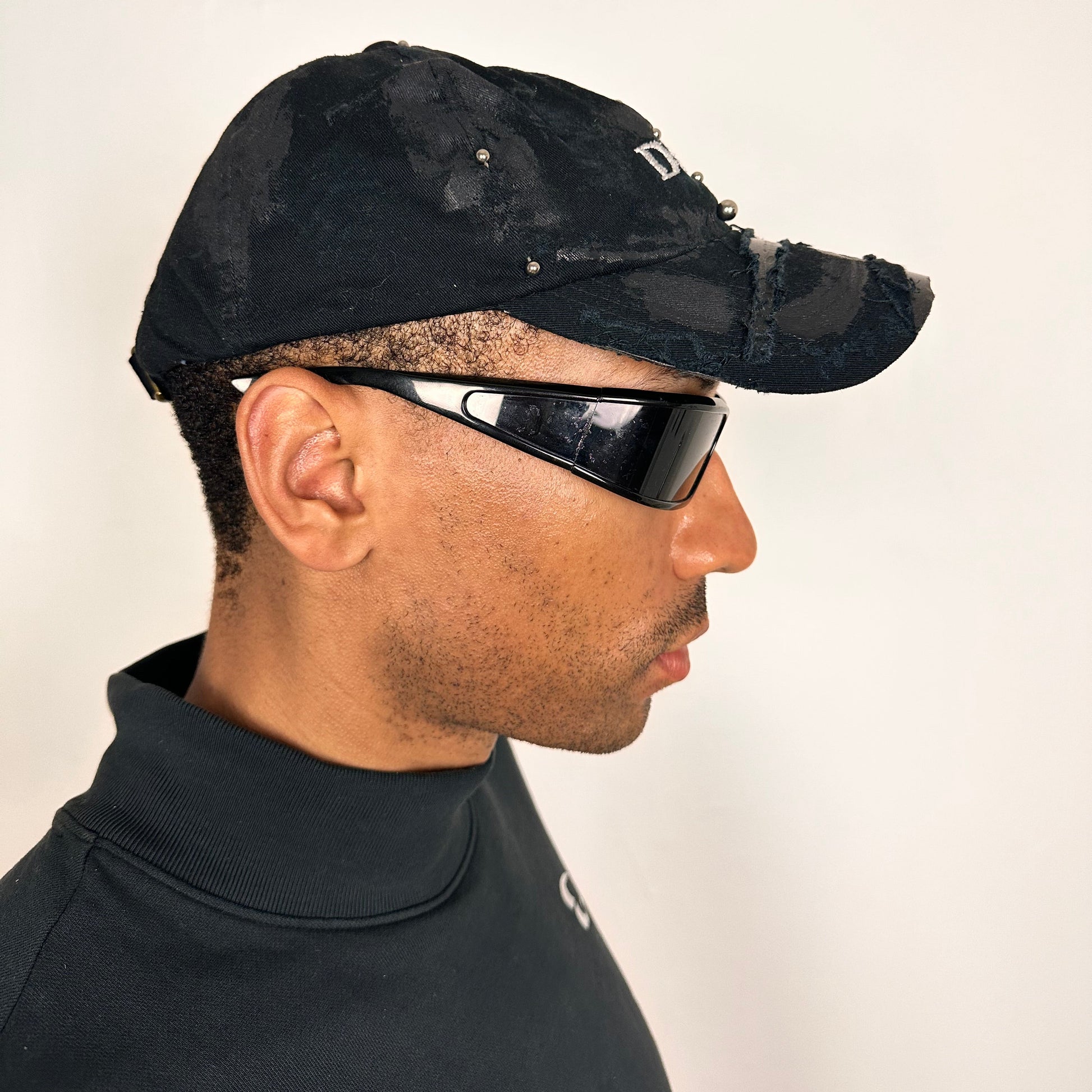 Right side of Black distressed ASTROBOI* ‘Daddy’ hat with custom paint detailing and stainless steel piercings, handcrafted in NYC.