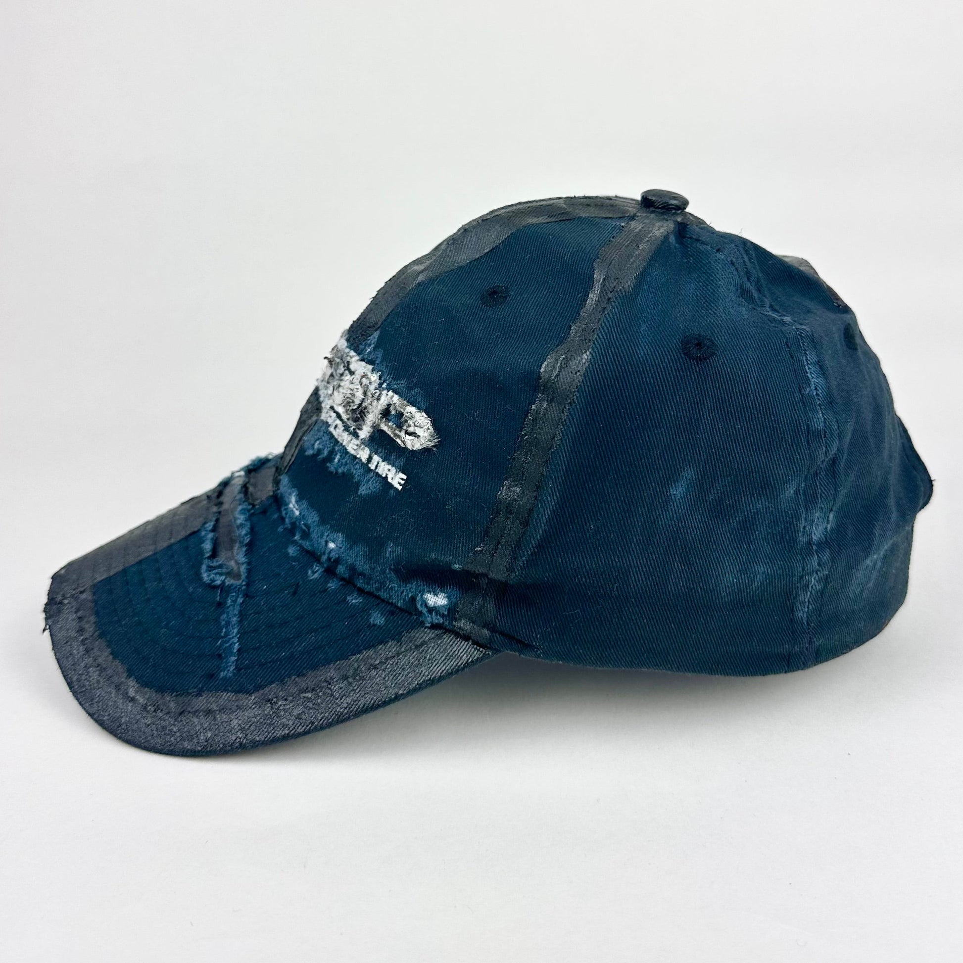 Left side product shot of ASTROBOI* RBP navy and black distressed utility hat with deconstructed visor, rhinestone logo sealed in resin, adjustable strap, custom NYC piece