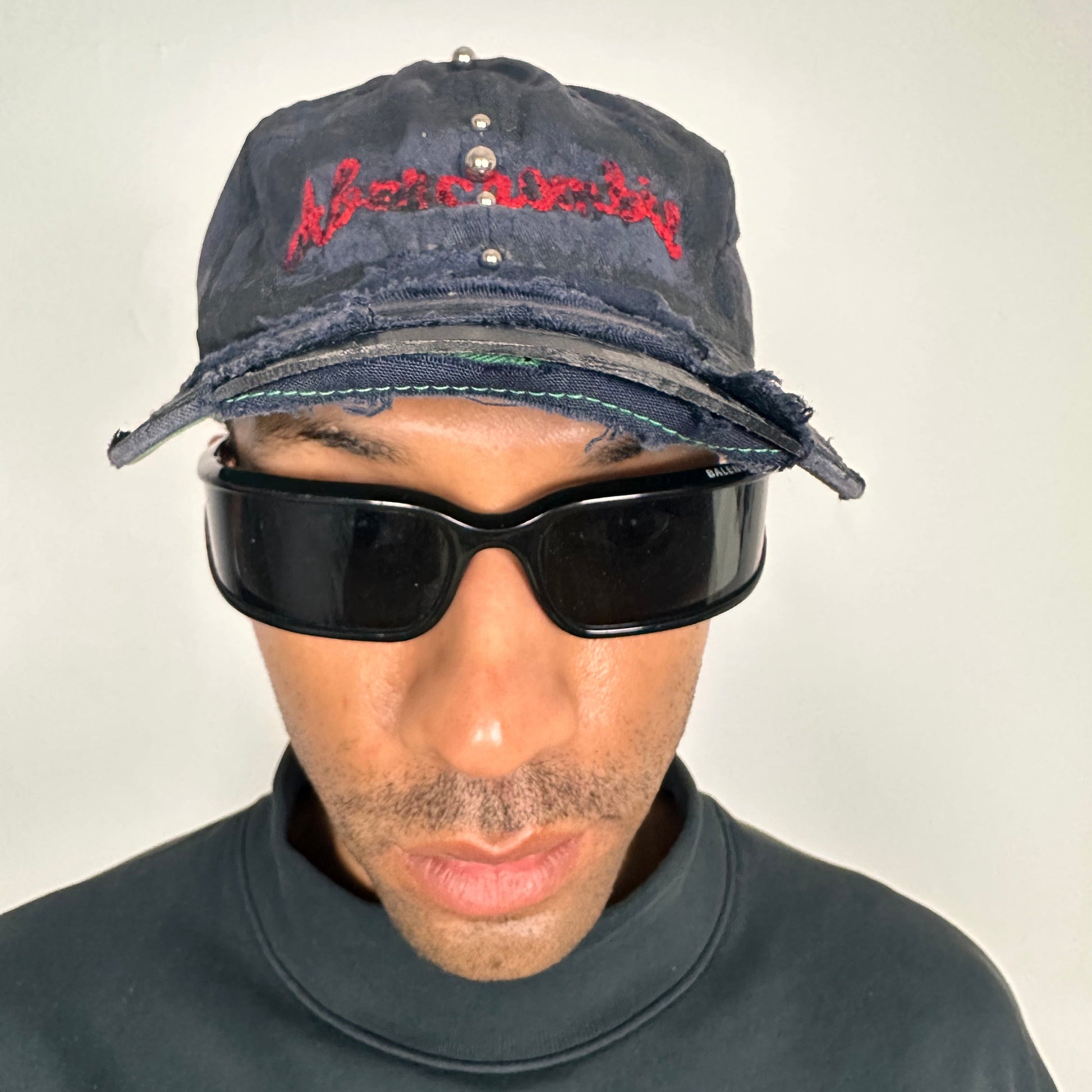 Front side of Navy ASTROBOI* x Abercrombie hat with distressed paint, stainless steel piercings, and logo embroidery on front and back, customized in NYC.