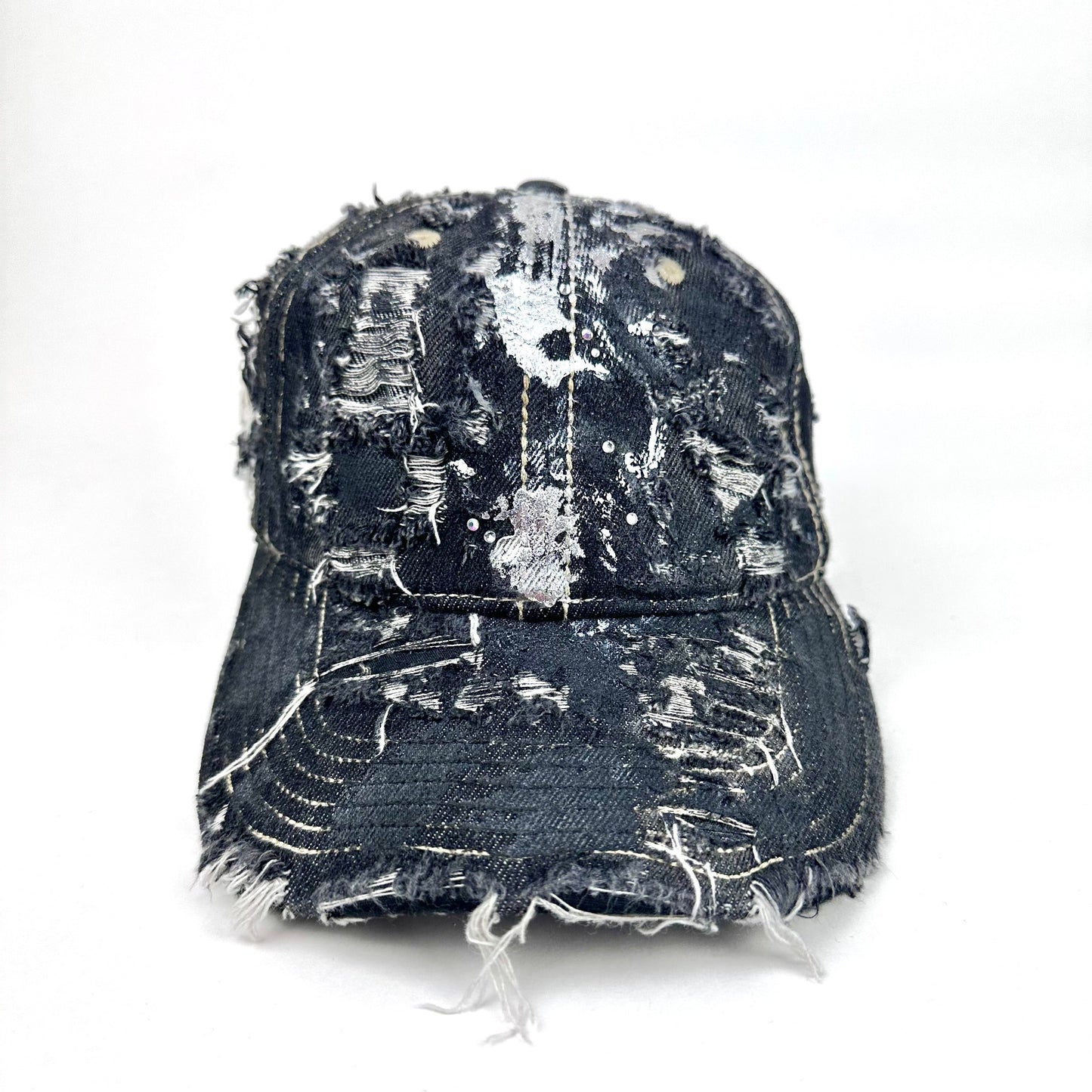 Distressed black cap with silver paint splashes on a white background