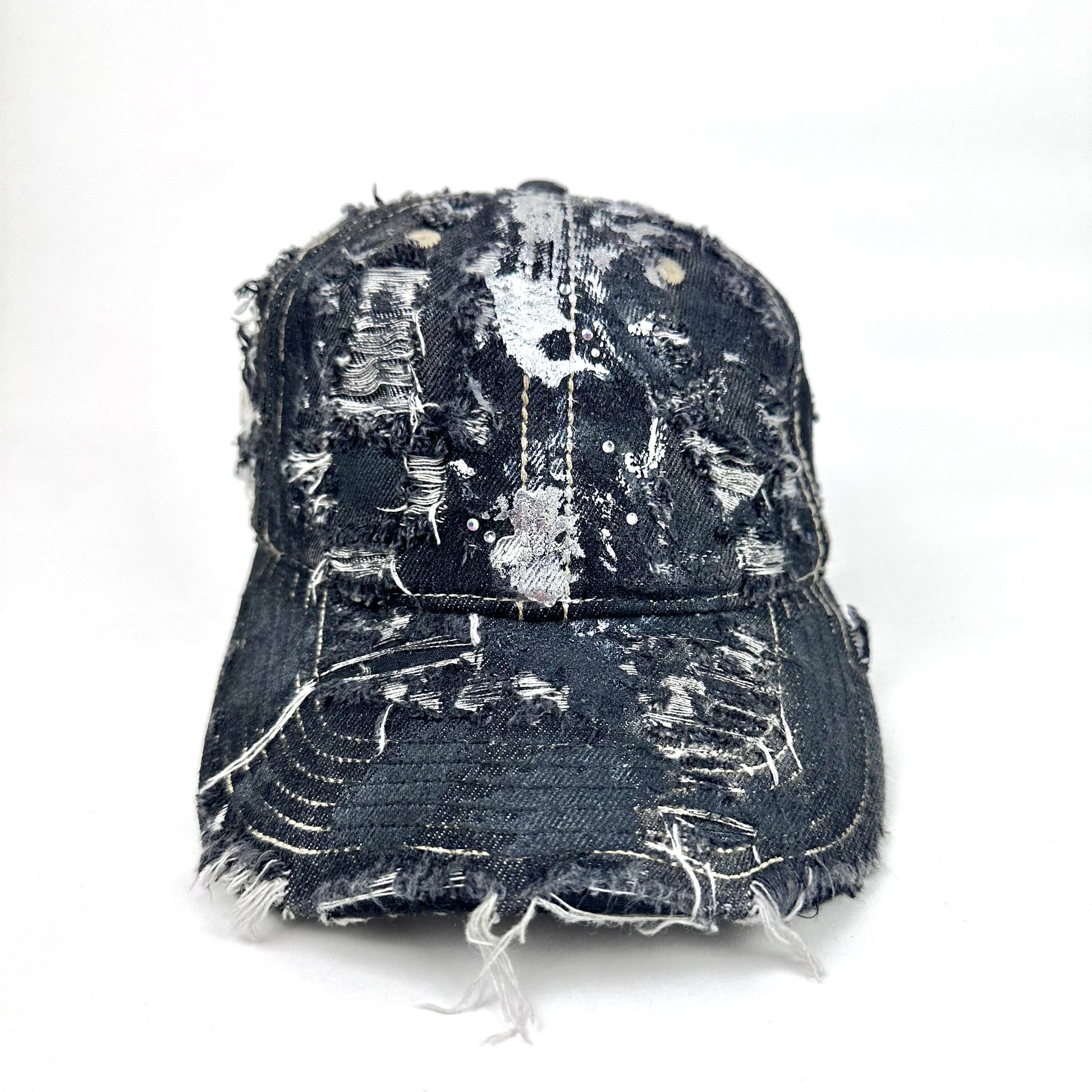 Distressed black cap with silver paint splashes on a white background