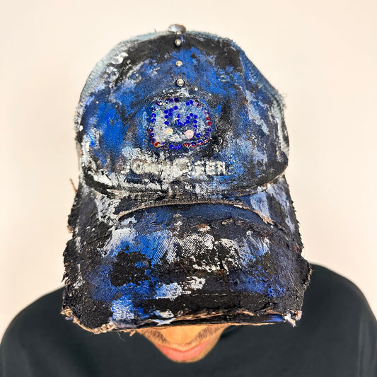 Front of ASTROBOI* x John Deere black and blue distressed trucker hat with rhinestone resin logo and stainless steel piercings.