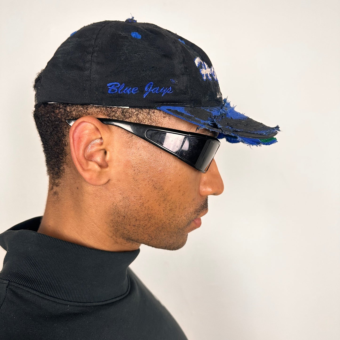 Right side of Black distressed ASTROBOI* Hopkins Lacrosse cap with blue embroidery and custom black paint treatment, snapback style, handcrafted in NYC.