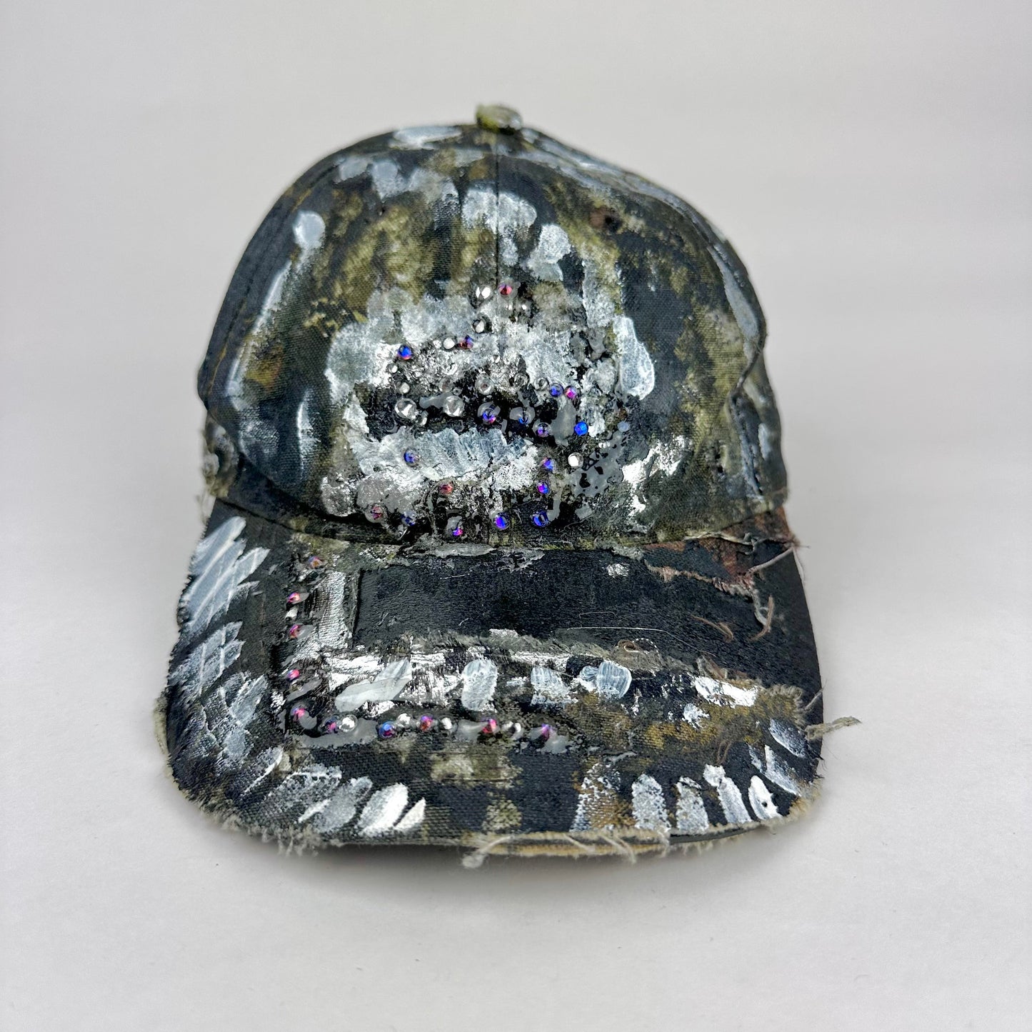 Black and white sequined baseball cap with rhinestone embellishments on a light gray background