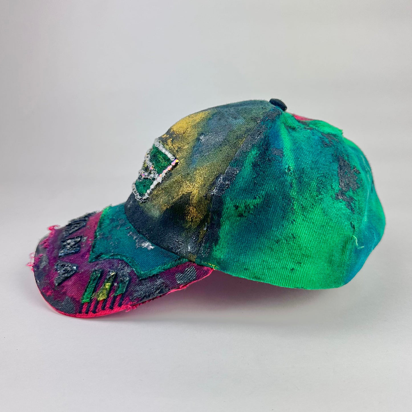 Left side product shot of ASTROBOI* Guyana yellow red green distressed baseball hat with resin-sealed rhinestone logo patch and adjustable strap, hand-customized in NYC
