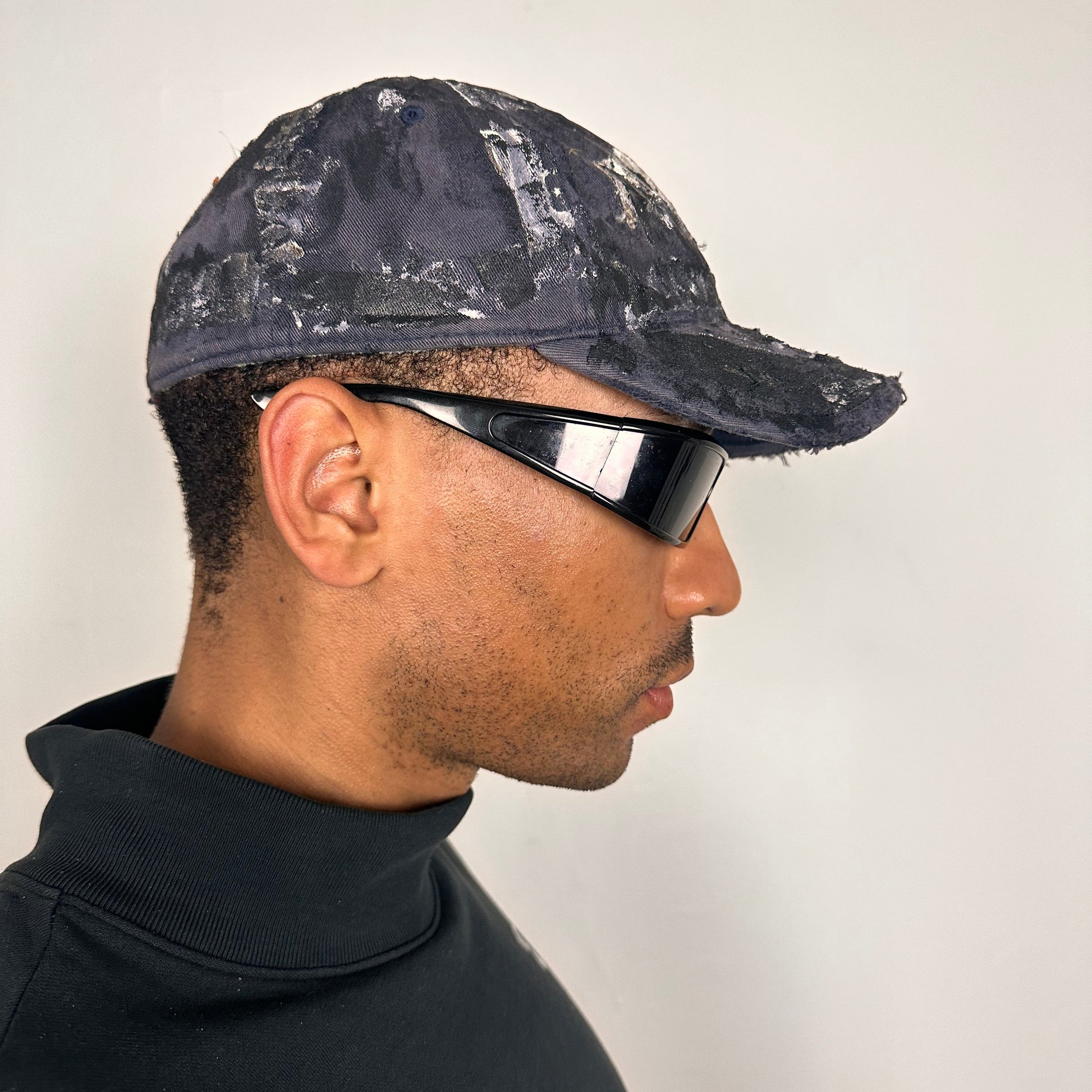 Right side of ASTROBOI* navy fitted cap with custom black, white, and silver paint and distressed vintage finish.