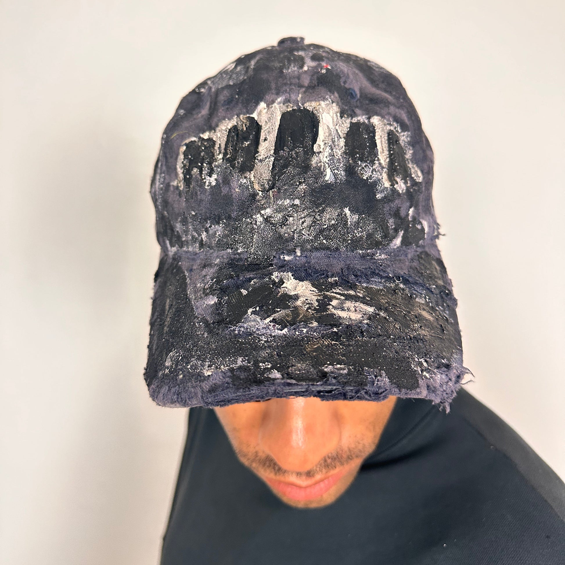 Front of ASTROBOI* navy fitted cap with custom black, white, and silver paint and distressed vintage finish.