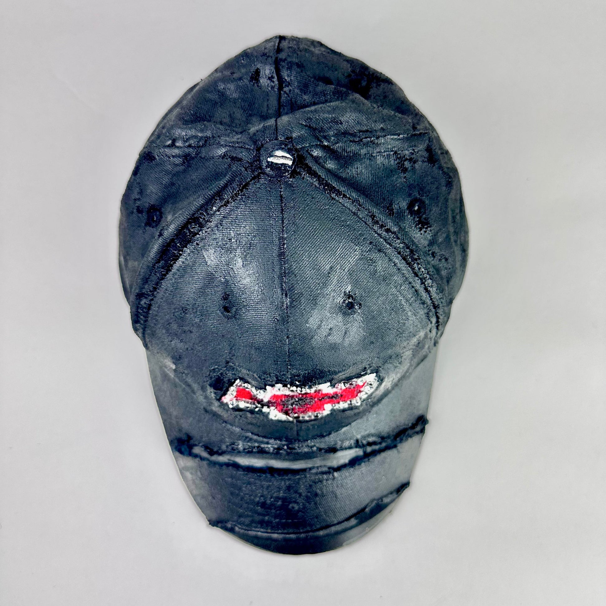 Still life top of ASTROBOI* x Chevy black distressed baseball hat with resin-sealed rhinestone logo, deconstructed visor, wax-painted tattoo details, adjustable fit