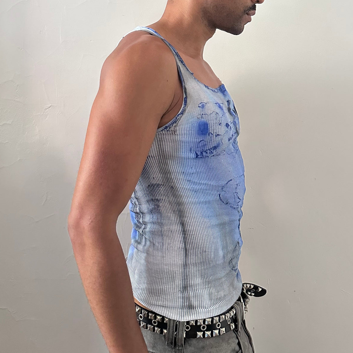 Right side detail of ASTROBOI* x Hanes 'Klein' showing blue and black faded tie dye swirl and paint splatter on slim-fitting white ribbed base.
