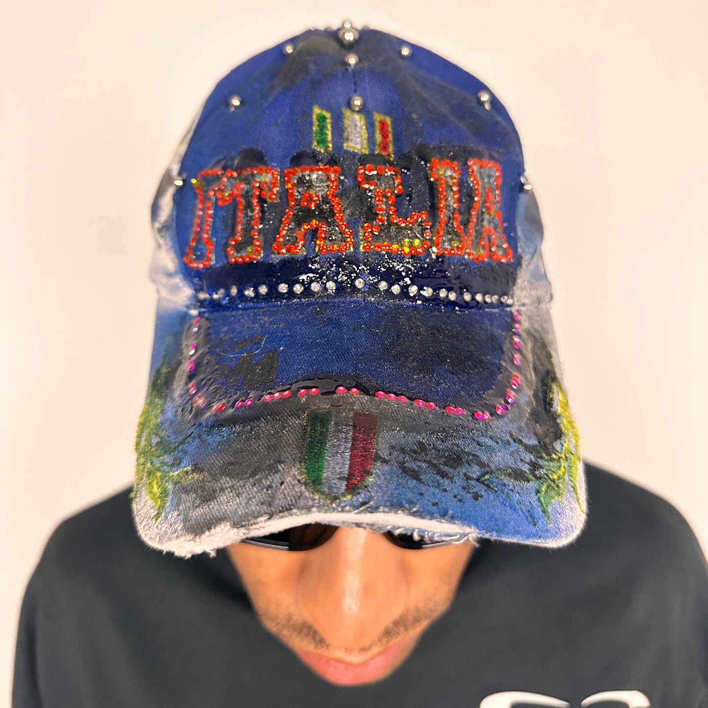 Front of Upcycled blue and white ASTROBOI* ‘ITALIA’ hat with rhinestones, resin, custom paint, and stainless steel piercings, handcrafted in NYC.