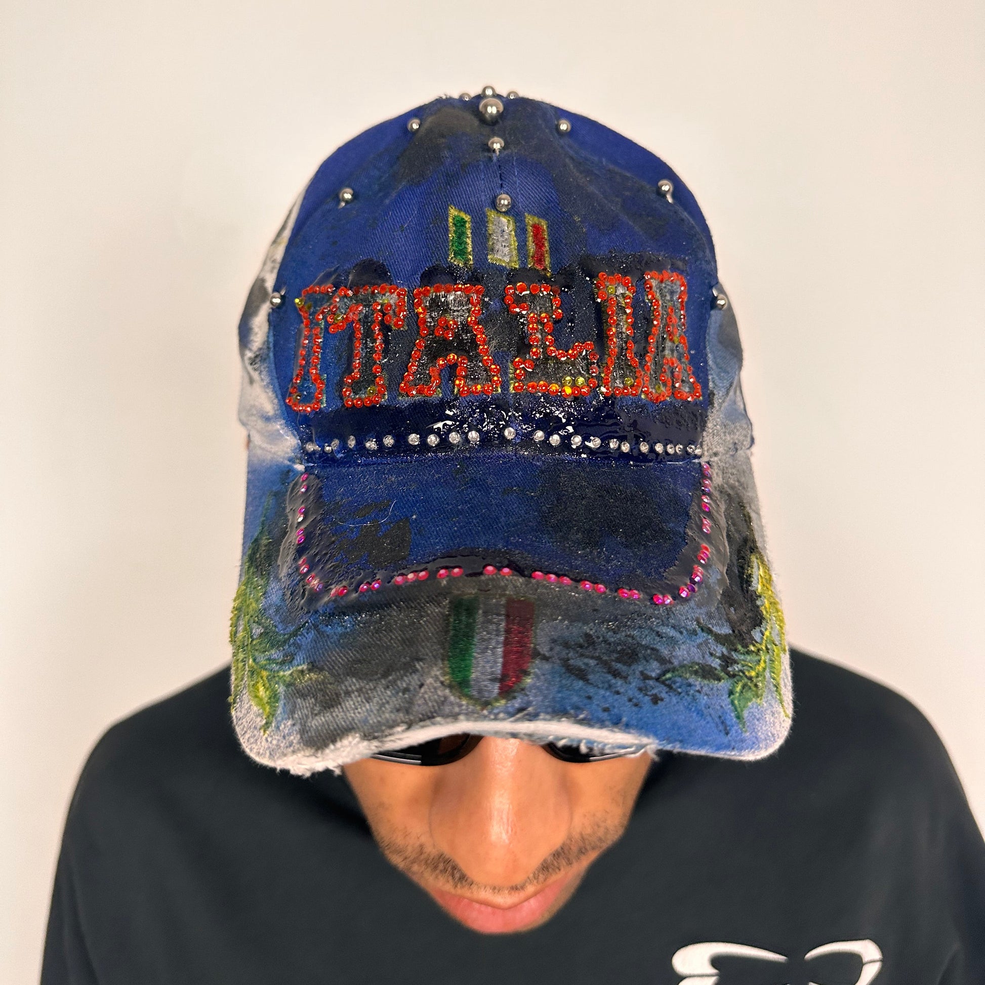 Front of Upcycled blue and white ASTROBOI* ‘ITALIA’ hat with rhinestones, resin, custom paint, and stainless steel piercings, handcrafted in NYC.