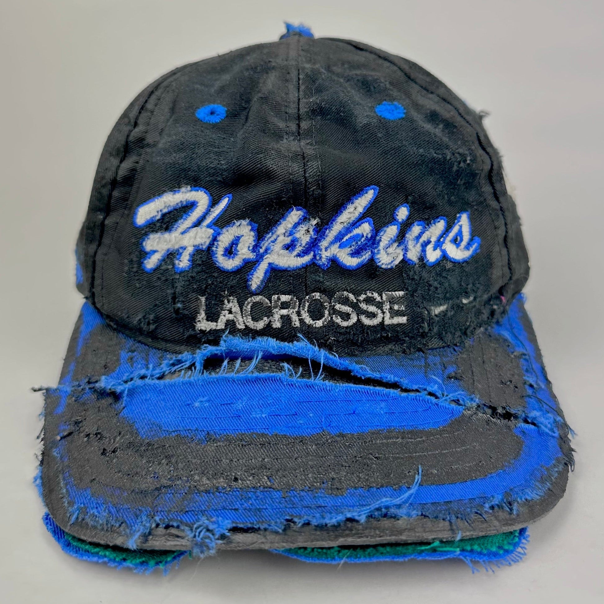 Front of Black distressed ASTROBOI* Hopkins Lacrosse cap with blue embroidery and custom black paint treatment, snapback style, handcrafted in NYC.