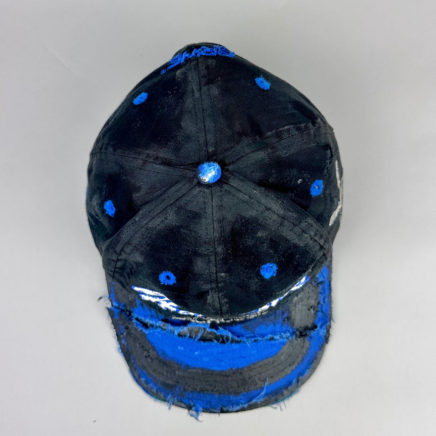 Top view of Black distressed ASTROBOI* Hopkins Lacrosse cap with blue embroidery and custom black paint treatment, snapback style, handcrafted in NYC.
