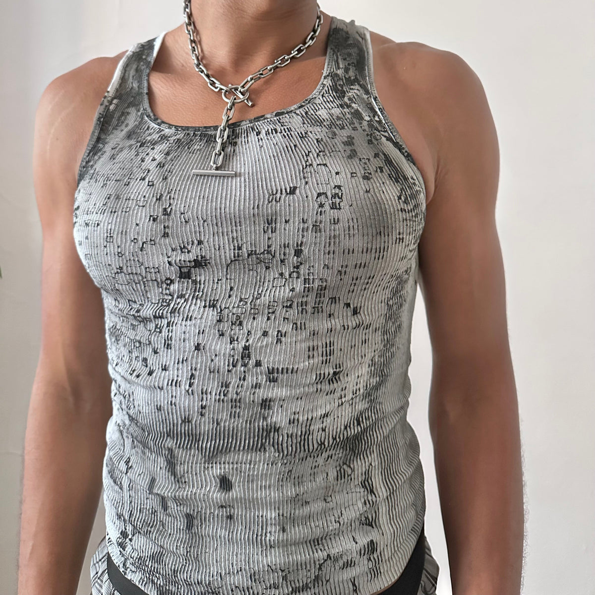 Close-up of ASTROBOI* x Hanes 'Digi Camo' showing washed out digital camo pattern and black faded stain detail on white ribbed 100% cotton fabric.