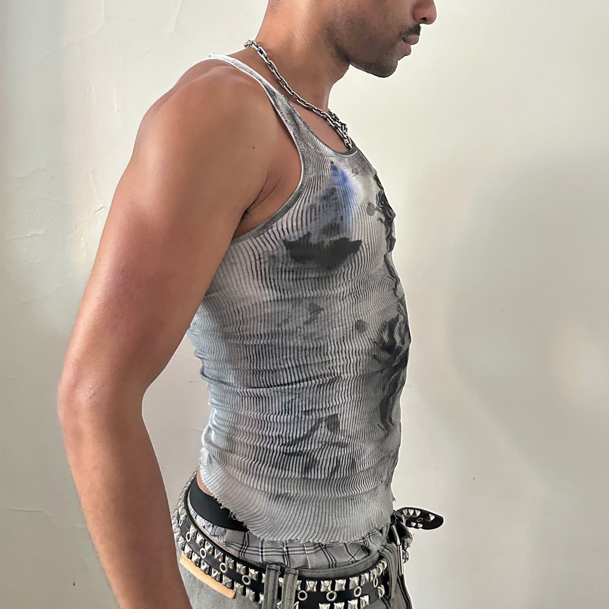 Right side detail of ASTROBOI* x Hanes 'Ice Dancer' showing blue and black faded tribal tattoo design and raw hemline on slim-fitting white ribbed base.
