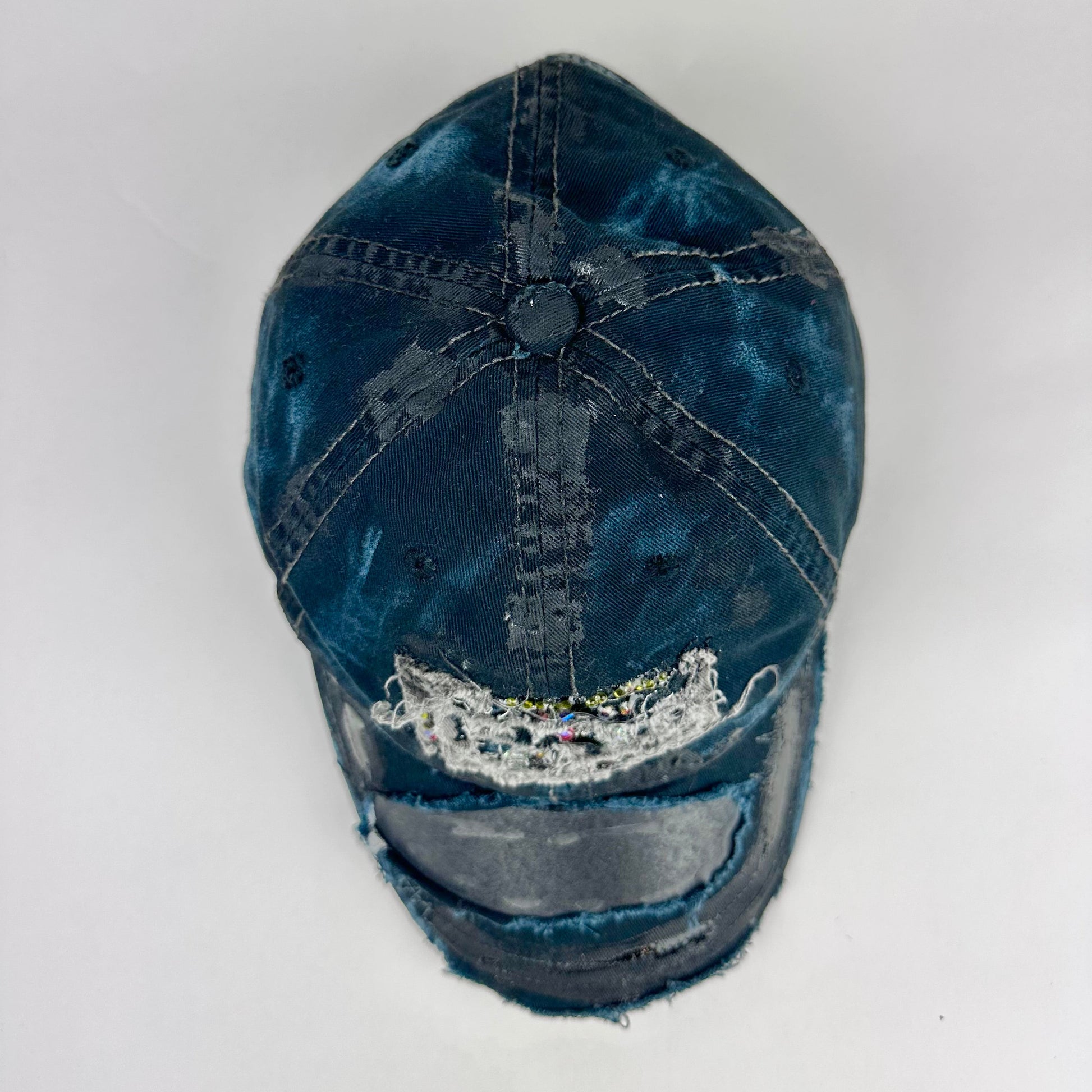 Top product shot of ASTROBOI* New York Aquarium navy distressed baseball hat with resin-sealed rhinestone logo, black waxed paint details, adjustable strap, custom NYC piece