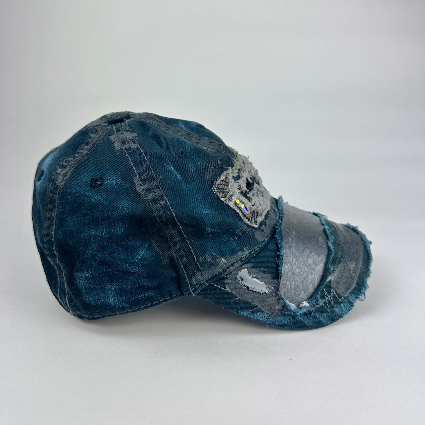 Right side product shot of ASTROBOI* New York Aquarium navy distressed baseball hat with resin-sealed rhinestone logo, black waxed paint details, adjustable strap, custom NYC piece