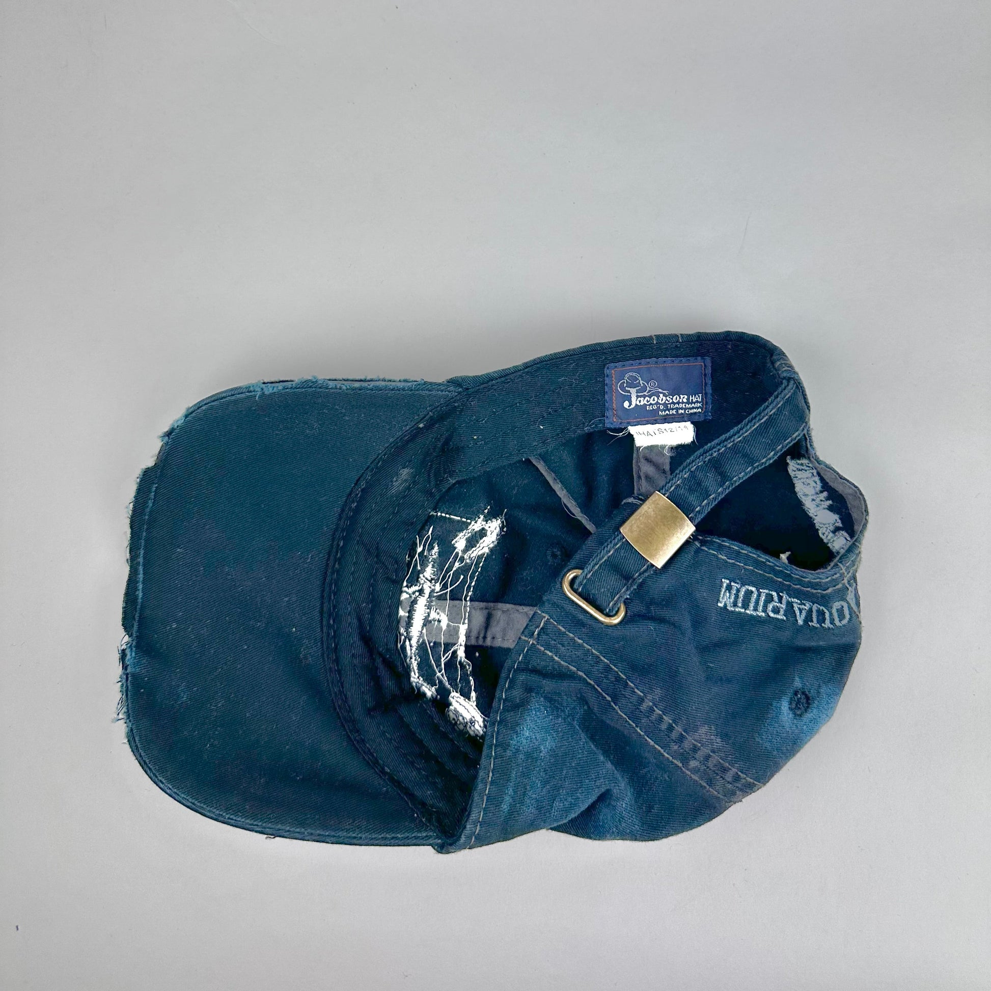 Back side product shot of ASTROBOI* New York Aquarium navy distressed baseball hat with resin-sealed rhinestone logo, black waxed paint details, adjustable strap, custom NYC piece