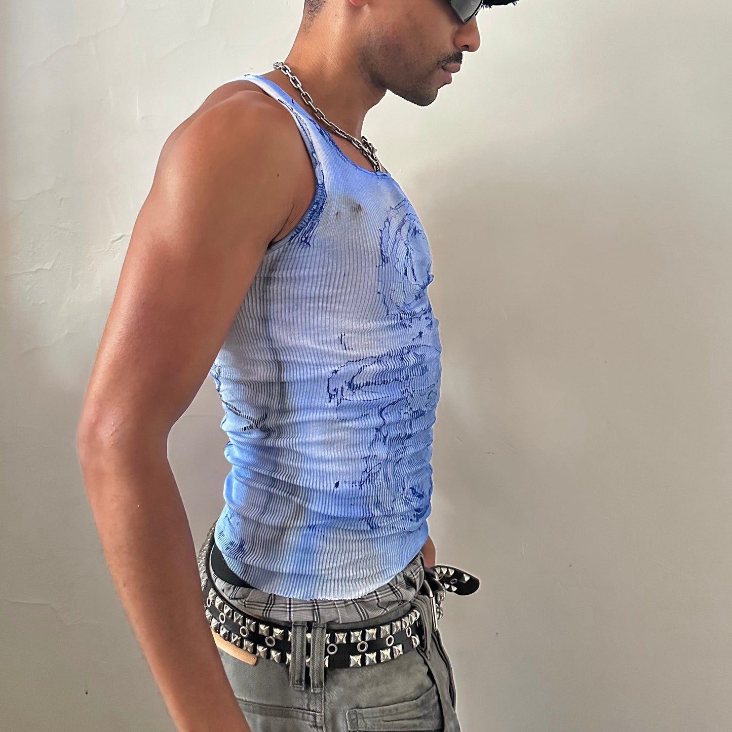 Right side detail of ASTROBOI* x Hanes 'Aero' showing blue and black faded swirl design and raw hemline on slim-fitting white ribbed cotton base.