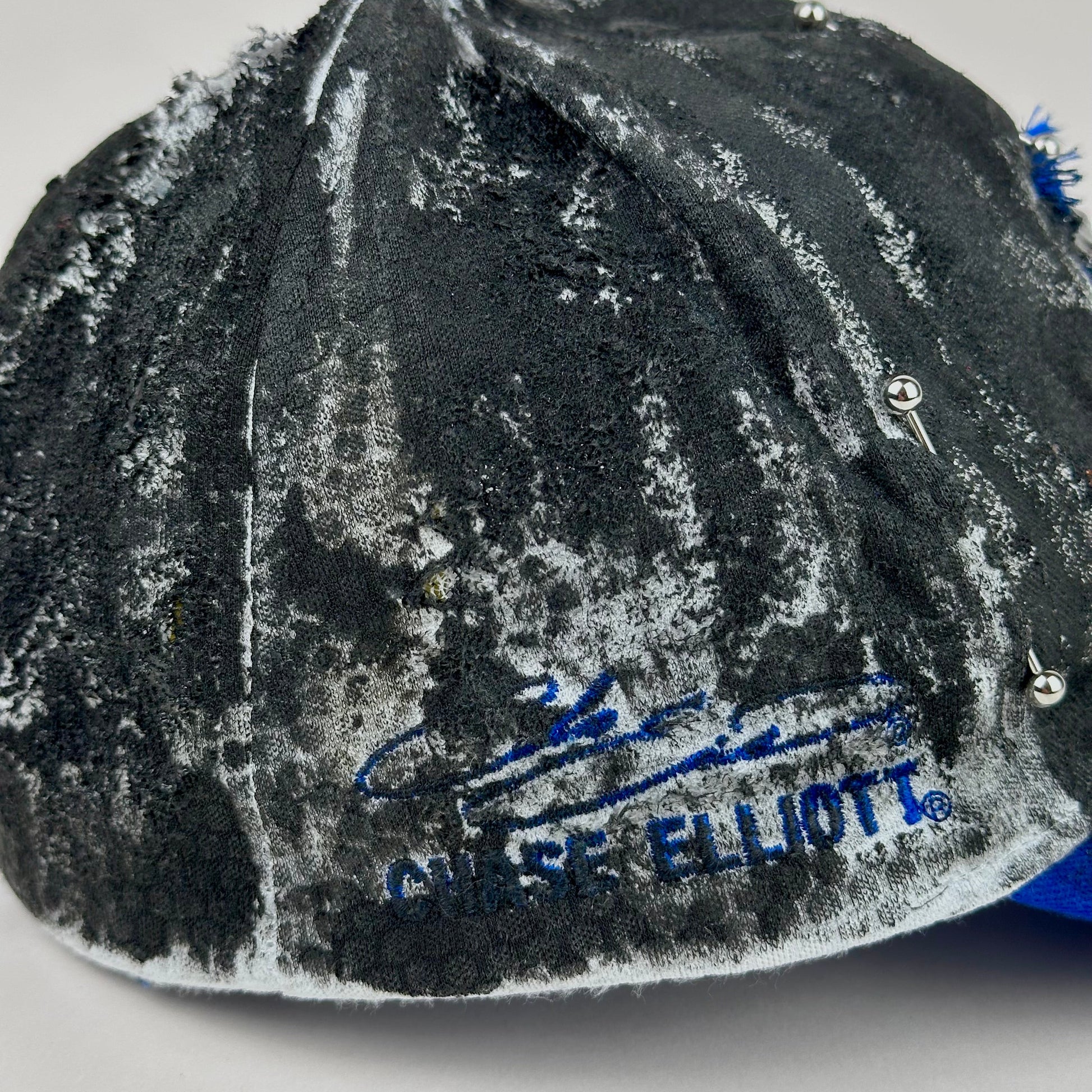 Embroidery of Chase Elliott on Blue and white ASTROBOI* NAPA hat with rhinestone-covered logo sealed in clear resin, stainless steel piercings, and a deconstructed visor, handcrafted in NYC.