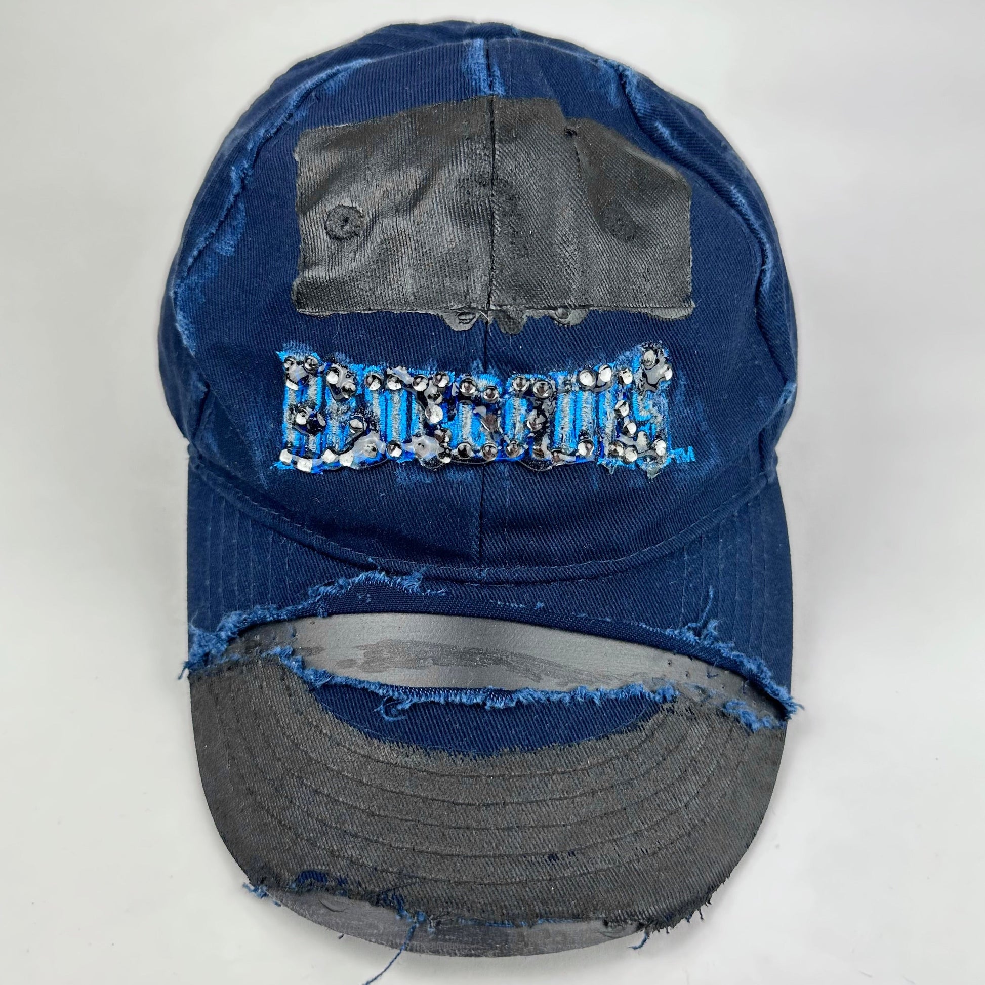 Front product shot of ASTROBOI* x Renegades navy distressed hat with resin-sealed rhinestones and tattoo-style paint details. One-of-one custom piece made in NYC.