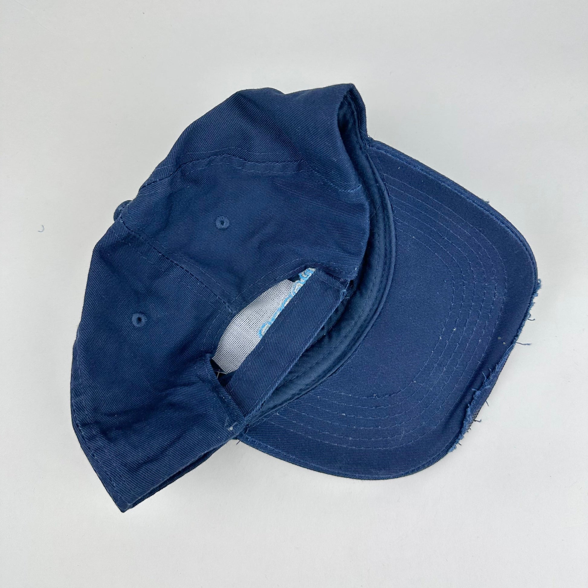 Back product shot of ASTROBOI* x Renegades navy distressed hat with resin-sealed rhinestones and tattoo-style paint details. One-of-one custom piece made in NYC.