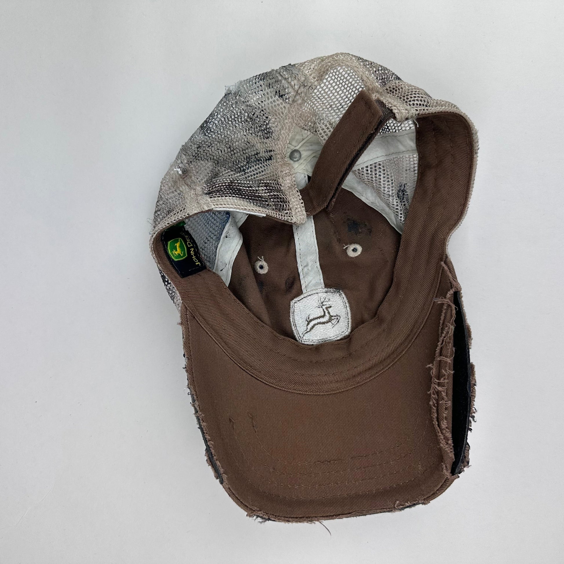 Back of ASTROBOI* x John Deere black and blue distressed trucker hat with rhinestone resin logo and stainless steel piercings.