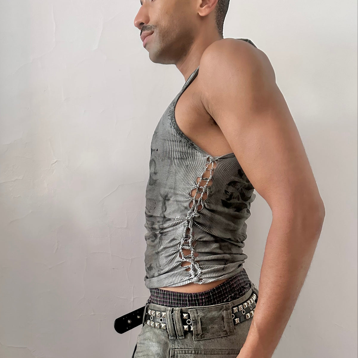 Left side detail of ASTROBOI* x Hanes 'Svartalfa' showing hand-painted black faded flame design and side braid detail on gray tank.