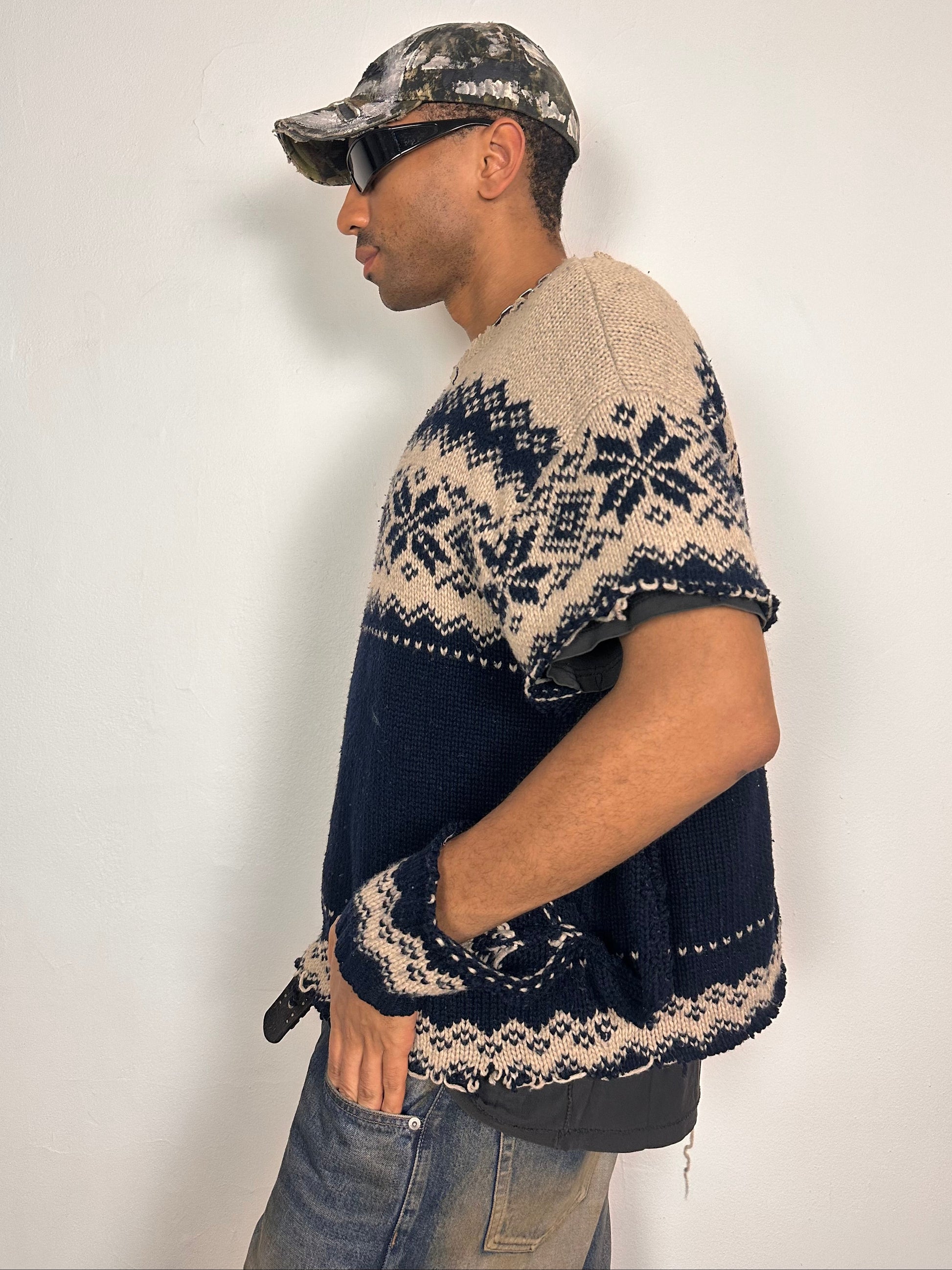 Left side of Deconstructed Fair Isle grunge sweater in XL with boxy fit, cutout sleeves, and raw hem, handmade by ASTROBOI* STUDIO in NYC.