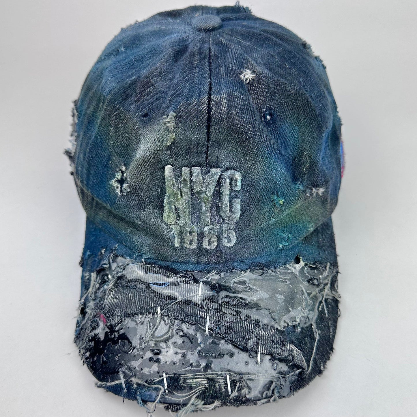 Distressed blue cap with 'NYC 1985' text on a white background
