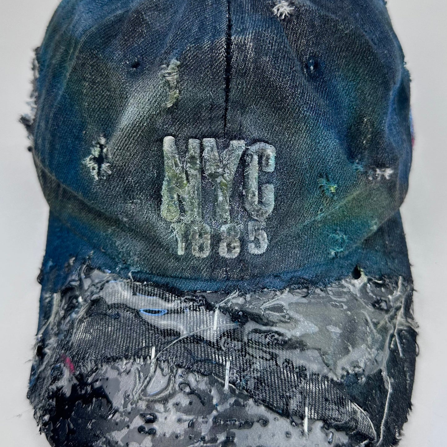 Blue distressed baseball cap with 'N.Y.C.' and '1865' text on a white background