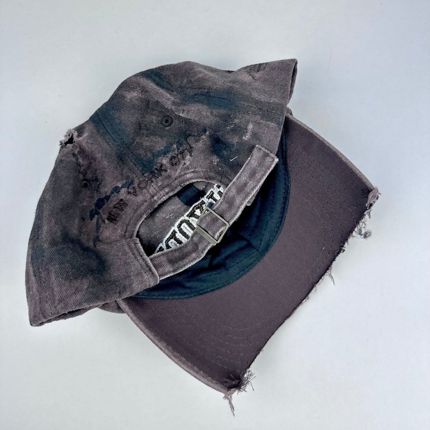 Back on ASTROBOI* New York brown and black distressed half-visor hat with bold logo, black paint accents, and deconstructed grunge design. Handmade in NYC.