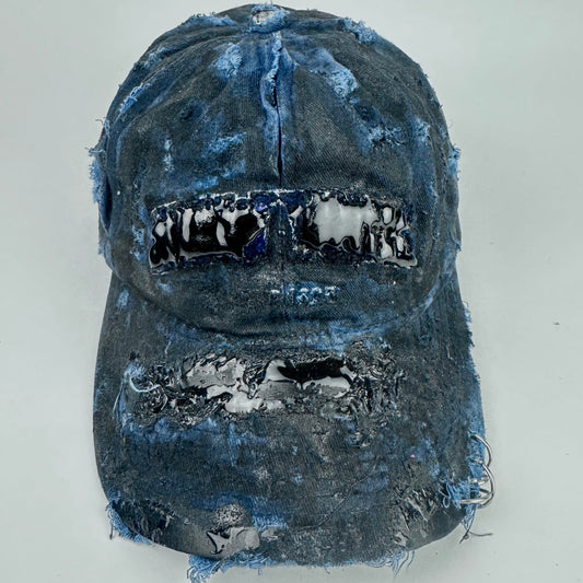 Front of ASTROBOI* 'Feeling Blue' distressed blue resin-coated hat with hand-painted black shading, metal piercings on the right front, and New York embroidery, handmade in NYC.