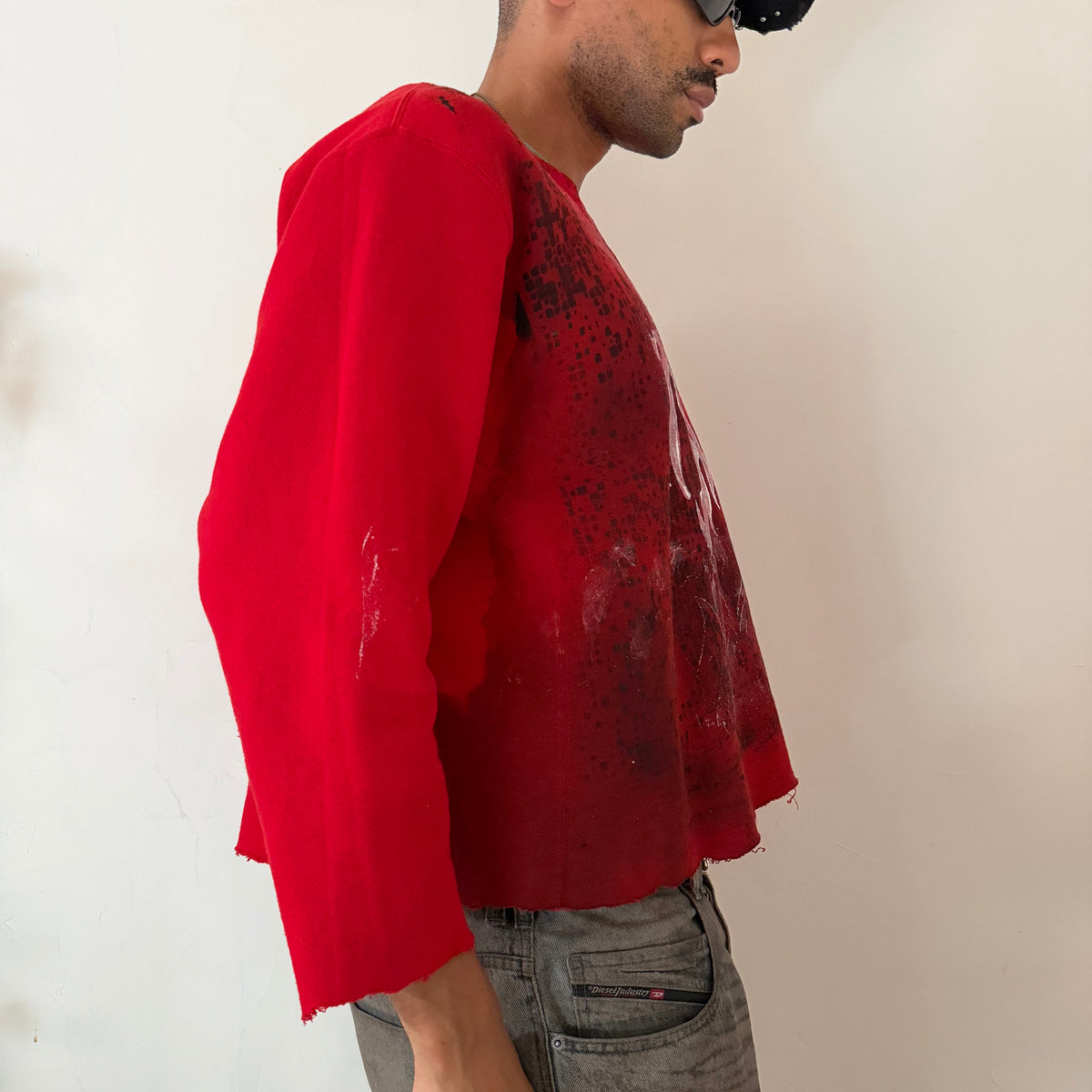 ight side detail of ASTROBOI* x Russell ‘Red Wave’ showing black digital camo print and white flame winged design on boxy red cotton base.