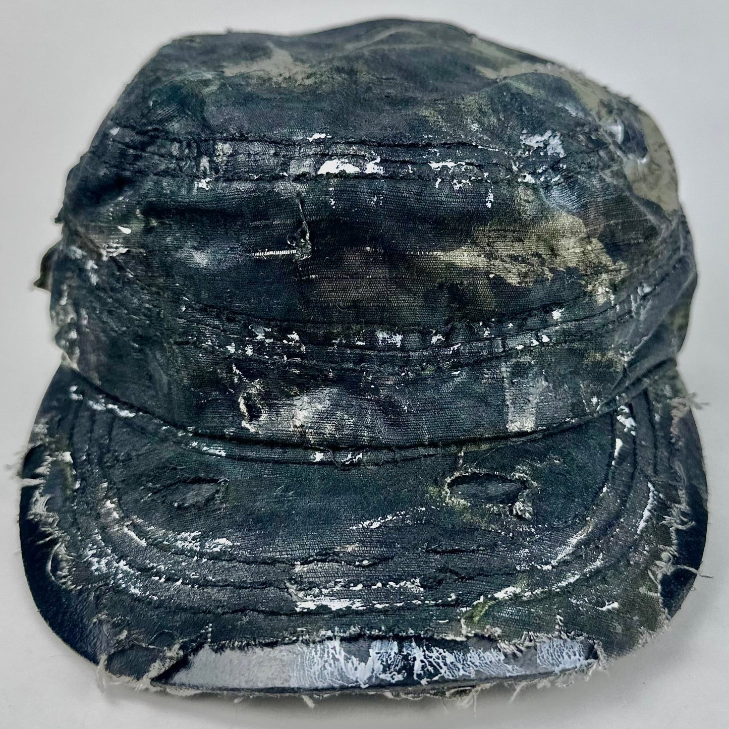 Worn black military-style hat on a light gray background