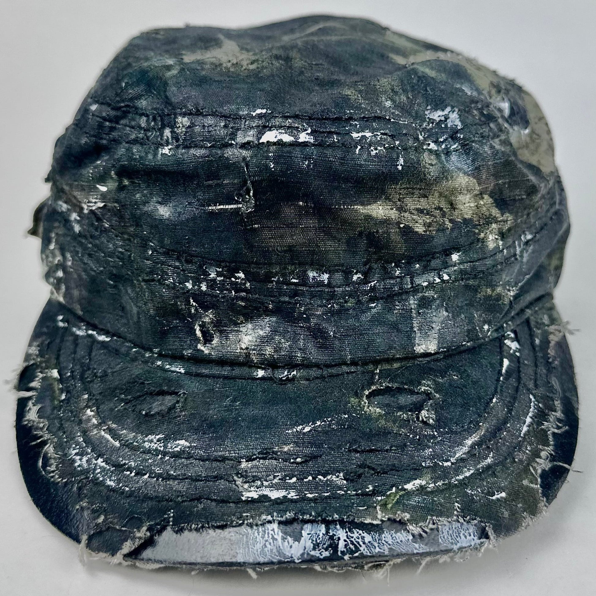 Worn black military-style hat on a light gray background