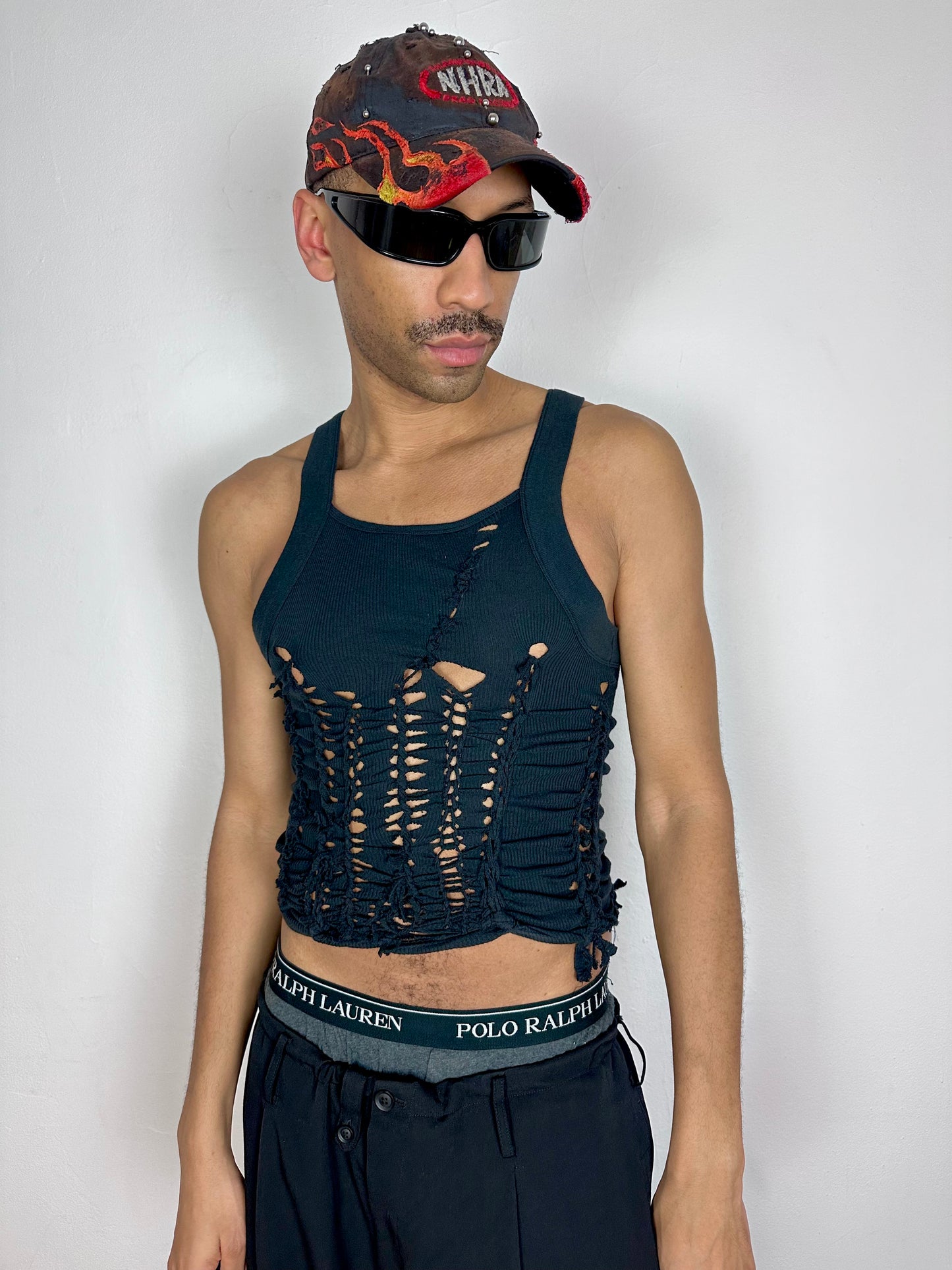 Male model wearing ASTROBOI* 'Abstract' black braided cut out Y2K tank top, styled full look, ASTROBOI* STUDIO NYC.