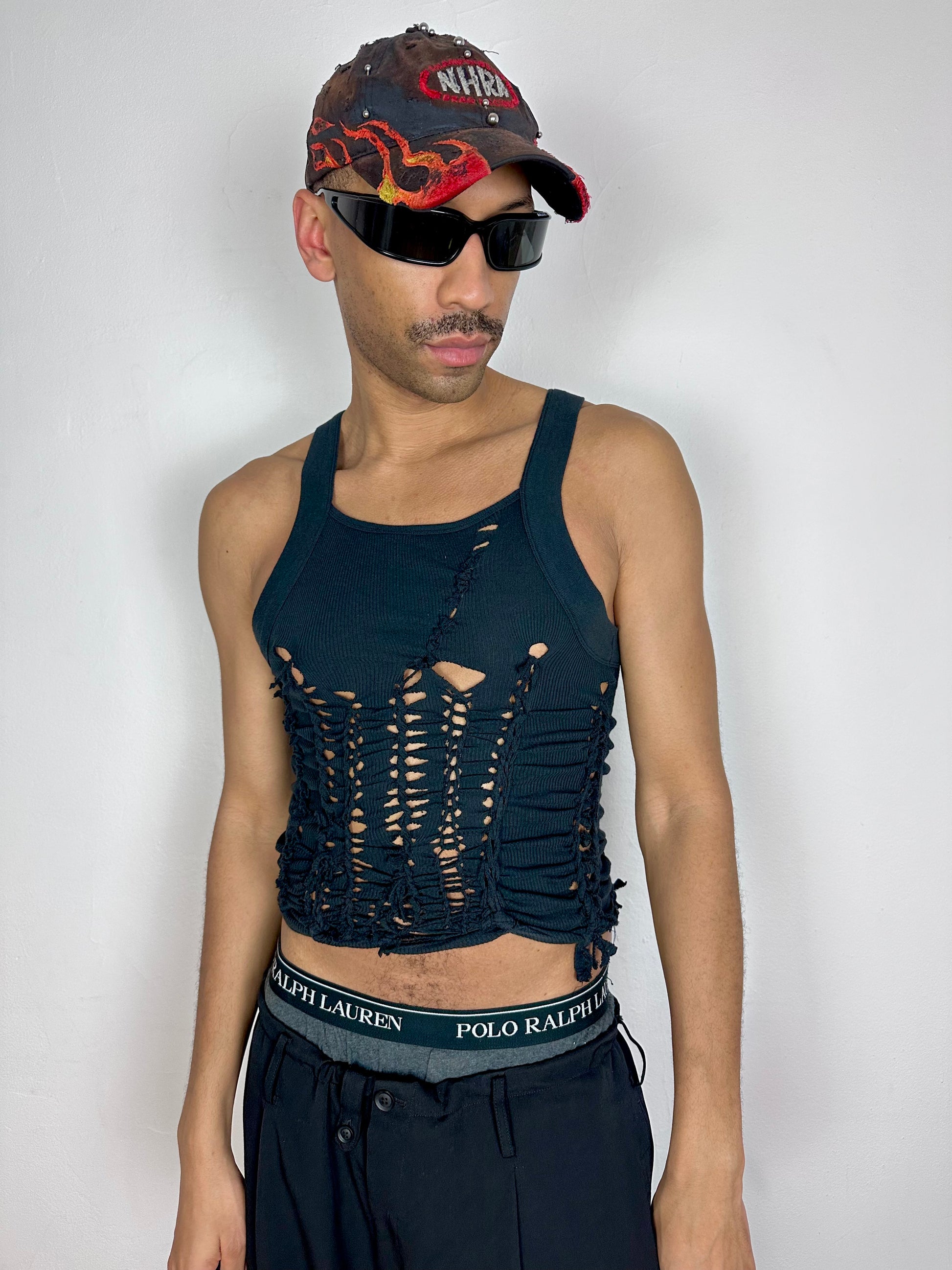 Male model wearing ASTROBOI* 'Abstract' black braided cut out Y2K tank top, styled full look, ASTROBOI* STUDIO NYC.